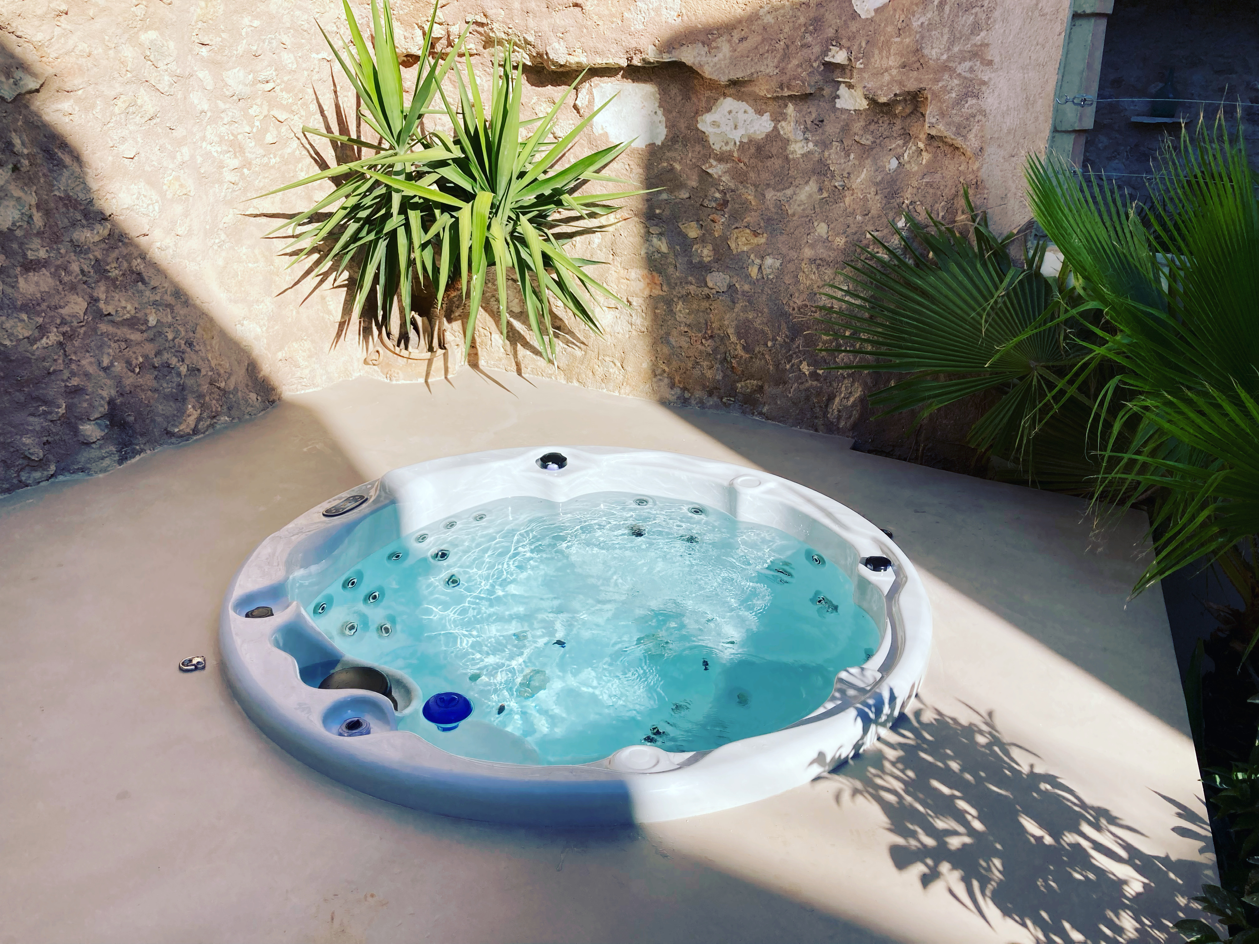 Round spa with Mediterranean plants and stone wall, Mallorca finca