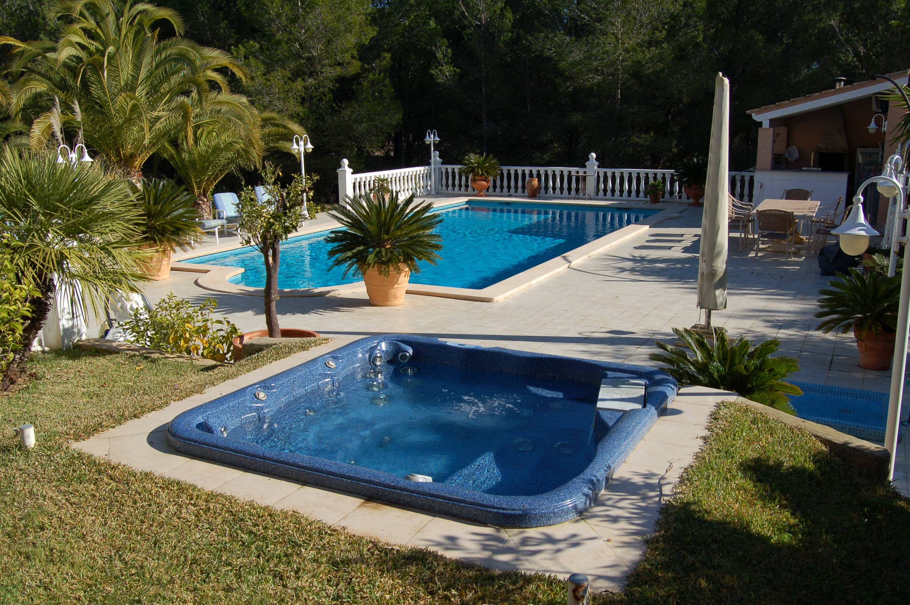 Blue jacuzzi installed next to pool at Mallorca property